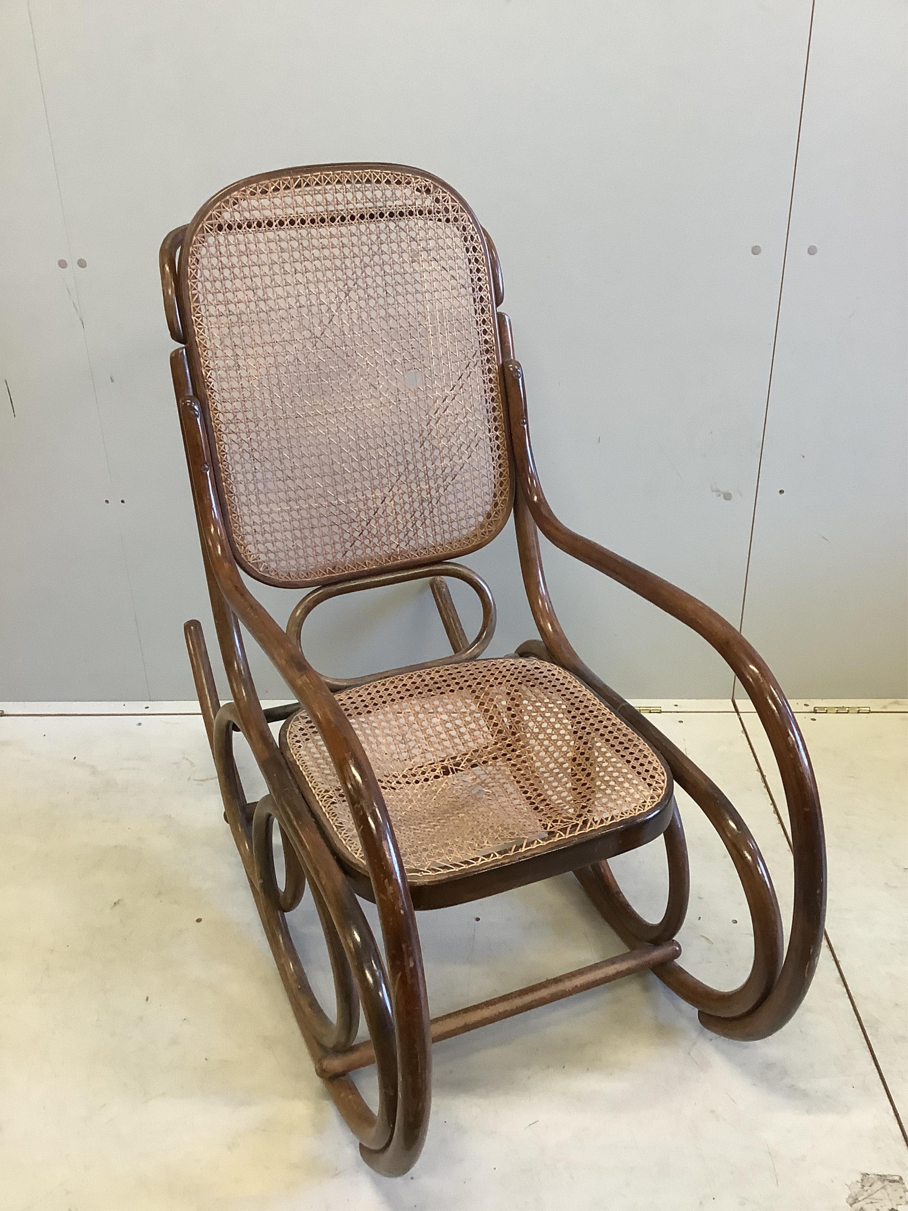 An early 20th century caned beech bentwood rocking chair, width 50cm, depth 112cm, height 98cm. Condition - fair, cane poor